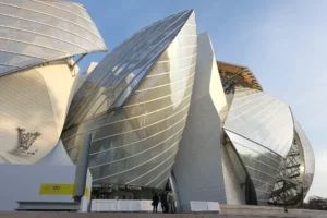 Image représentant la Fondation Louis Vuitton, un bâtiment architectural spectaculaire entouré par le Bois de Boulogne.