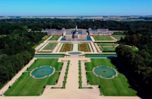 Image du majestueux Château de Vaux-le-Vicomte, entouré de ses somptueux jardins à la française.